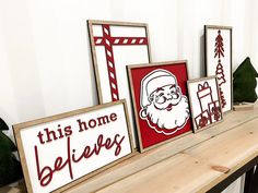 three wooden signs with santa's face on them sitting on top of a shelf