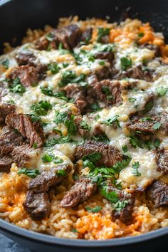 a skillet filled with meat and cheese covered in parsley on top of rice