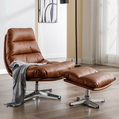 a brown leather chair and ottoman in a living room