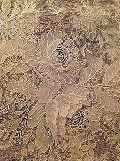 an old lace table cloth with flowers on it