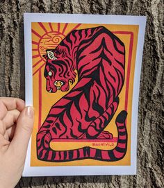 a hand holding up a card with a tiger on it