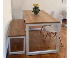 a wooden table sitting next to a white chair on top of a hard wood floor