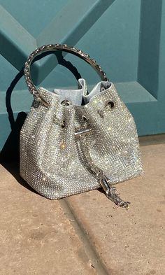 This Crystal Bag is an elegant accessory featuring a full-covered rhinestone design, a detachable chain strap, and a small pouch with a hard crystal metal handle. Perfect for adding a touch of sparkle and sophistication to any ensemble, this bag is a must-have for any fashion-forward wardrobe. Chic Evening Bag With Bling For Night Out, Sparkling Crystal Bags For Party, Chic Embellished Crystal Evening Bag, Glamorous Handheld Bag With Chain Strap, Chic Bling Clutch Evening Bag, Glamorous Silver Bag With Detachable Handle, Glamorous Handheld Evening Bag With Bling, Glamorous Handheld Evening Bag With Rhinestones, Glamorous Silver Shoulder Bag With Chain Strap