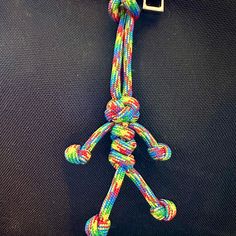 there is a multicolored rope attached to the back of a shirt with a square buckle on it