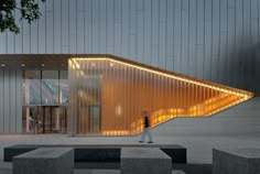 a person walking in front of a building that has a large triangular design on it