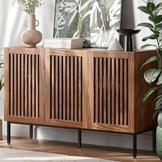 a wooden cabinet sitting next to a potted plant