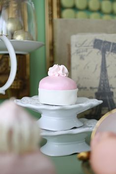 there is a small cake that is on top of the plate and it has pink icing