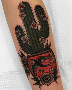 a cactus tattoo on the arm with red and black ink, flowers and leaves around it