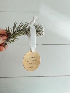 a hand holding a gold ornament that says peace, pattern, football, and flowers