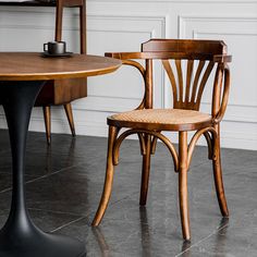 two wooden chairs sitting next to each other near a table