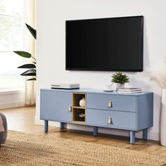 a flat screen tv mounted to the side of a blue cabinet in a living room