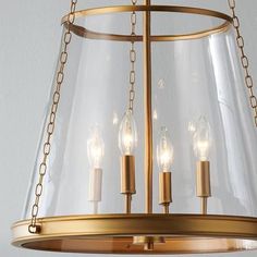 a brass chandelier with three candles hanging from it