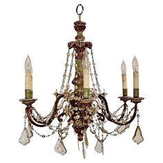 an antique chandelier with crystal drops hanging from it's arms and two candles in the center