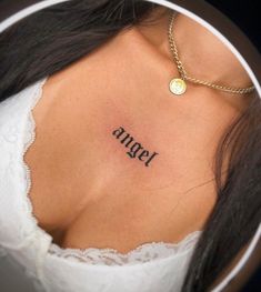 a woman's chest with the word angel tattooed on it