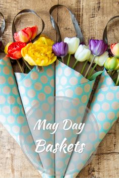 colorful flowers are in a paper bag with the words may day baskets