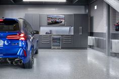 a blue car parked in a garage next to a wall mounted tv on the wall