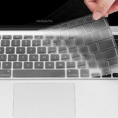 a person is typing on the keyboard of a laptop with an adhesive sticker over it