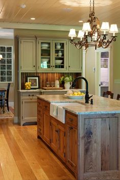 a large kitchen with an island in the middle and lots of cabinets on both sides