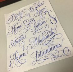 some type of calligraphy that is on top of a piece of paper with blue ink