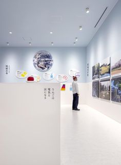 a man standing in front of a white counter with pictures on the wall behind him