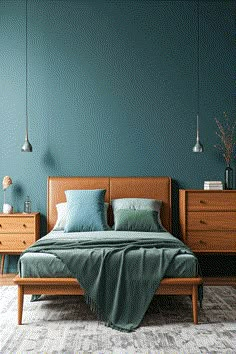 a bed with blue sheets and pillows in a room that is painted teal green