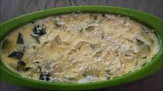 a green bowl filled with food on top of a table