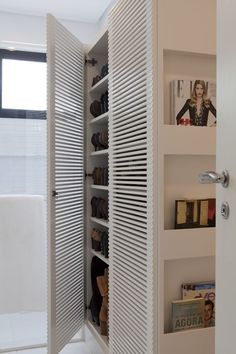 an open closet with shoes and magazines in it