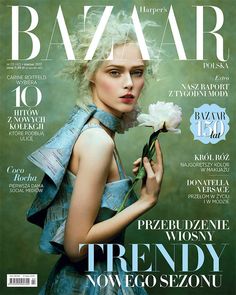 a woman holding a flower on top of a magazine cover