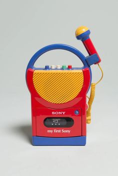 a toy radio with a microphone attached to it's back end and the words my first song written on its front