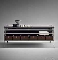 the sideboard is made from metal and has compartments for plates, bowls and cups on it