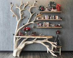 a wooden tree shelf with christmas decorations on the top and shelves above it, in front of a gray wall