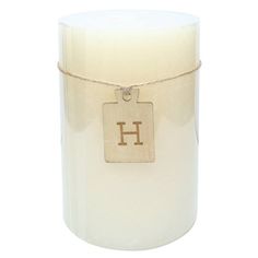 a white candle with a wooden tag on the front and bottom that says h hanging from a rope