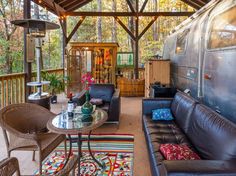 a living room with couches, chairs and a coffee table in front of an airstream