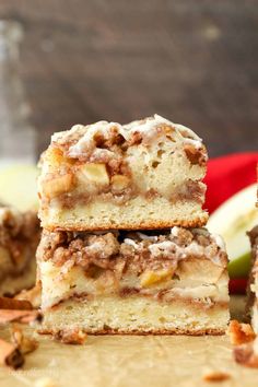 three pieces of apple pie stacked on top of each other with apples in the background