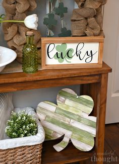 a wooden sign sitting on top of a table next to a vase filled with flowers