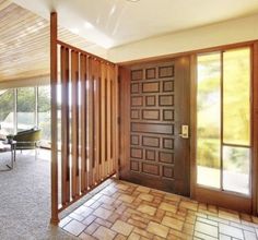 an empty room with wood paneling and sliding glass doors that lead into the living area