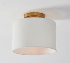 a white lamp hanging from the ceiling in a room with a light fixture on it