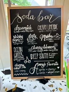 the menu for soda bar is displayed on a blackboard with white writing and colorful straws