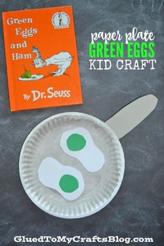 a paper plate with green eggs on it and a book about dr seuss in the background