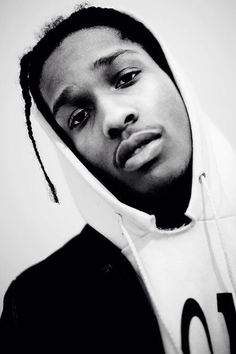 a black and white photo of a man with dreadlocks wearing a hoodie