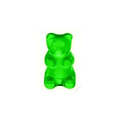 a green gummy bear sitting up against a white background