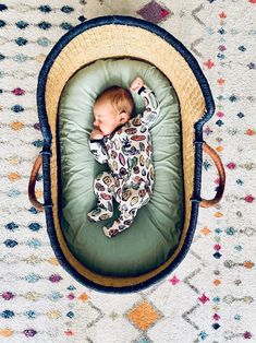 a baby is laying in a basket on the floor