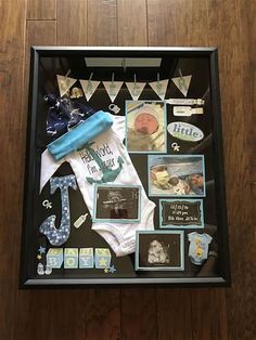 a baby's first birthday gift in a shadow box with pictures and other items