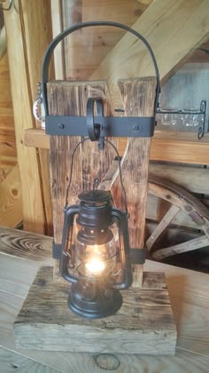 an old fashioned lantern is sitting on top of a wooden block with a light inside