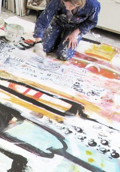 a woman is painting on the floor with black and white paint