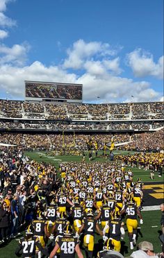 a football game is being played in a stadium with many people standing on the sidelines