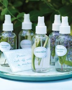 several bottles with flowers in them sitting on a table next to some cards and labels