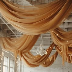 a room filled with lots of drapes and chandelier hanging from the ceiling