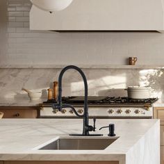 a kitchen with marble counter tops and an island in front of a stove top oven