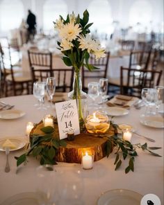 a centerpiece with flowers and candles is displayed on a table at a wedding reception